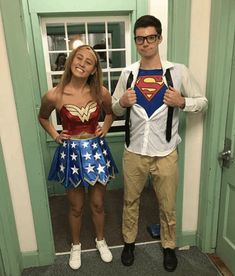 a man and woman dressed up as superman and wondergirl standing next to each other