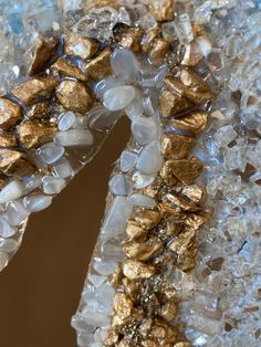 some gold and white rocks are in the middle of a piece of glass that has been placed