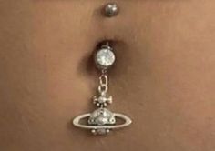 a woman's belly is shown with an attached ring and dangling earrings on it