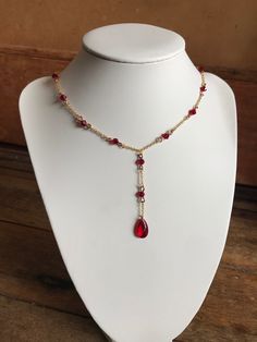 this necklace features a deep, blood-red gemstone, adorned with glass red beads and tarnish resistant chains for those who embrace the darkness with elegance. Red Beaded Ruby Necklace, Red Beaded Chain Necklace Gift, Gift Red Beaded Chain Necklace, Red Beaded Chain Necklace For Gift, Elegant Red Beaded Chain Necklace, Red Adjustable Chain Necklace For Party, Elegant Red Wire Wrapped Necklace, Blood Necklace, Vampire Style