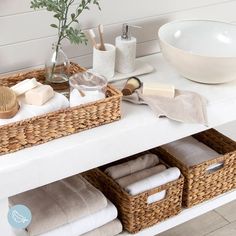 the bathroom counter is organized with baskets and towels