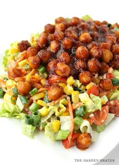 a white plate topped with lettuce and chickpeas