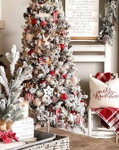 a decorated christmas tree in a living room with red and white ornaments on the top