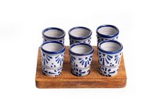 six blue and white cups sitting on top of a wooden tray