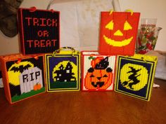 four bags with halloween designs on them sitting on a table in front of a wall