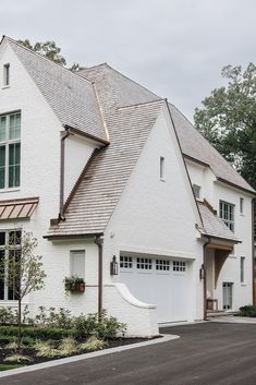 a large white house with two garages and windows on the side of the building