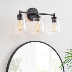 a bathroom vanity light with three bulbs on it and a mirror in front of it