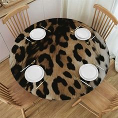 an animal print table cloth with white plates on it