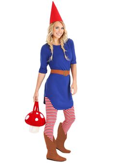 a woman in a blue dress and red hat is holding a mushroom shaped bag while standing with her legs crossed