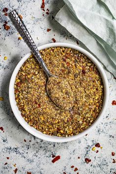 a white bowl filled with granola on top of a table next to a spoon