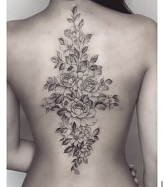 a woman's back tattoo with flowers on it