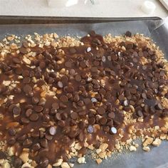 a cookie sheet covered in chocolate chips and peanut butter on top of a baking pan