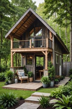 a small wooden cabin in the middle of some trees and grass with stairs leading up to it