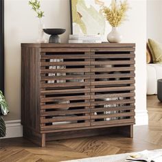 a wooden cabinet sitting on top of a hard wood floor next to a white rug