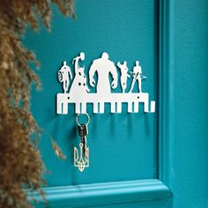 a key chain hanging on the side of a blue door with silhouettes of people