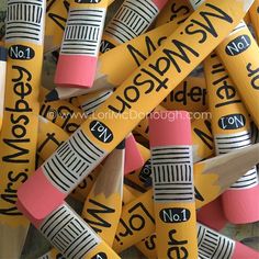 some crayons that are yellow and pink with black writing on them, all in the same color