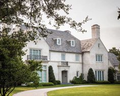 a large white house sitting on top of a lush green field