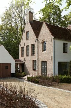 a large brick house surrounded by trees and shrubs