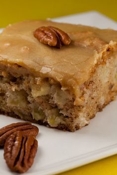 a piece of cake on a plate with pecans