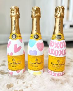 three bottles of champagne with hearts on them