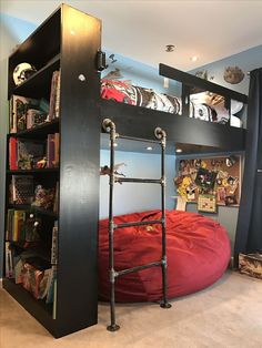 a bunk bed with a red bean bag on top and shelves above it, in a room with carpeted flooring