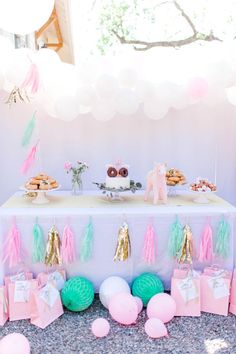 a table topped with lots of desserts and balloons