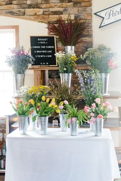 a table topped with lots of vases filled with flowers