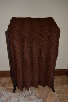 a brown blanket sitting on top of a wooden stand