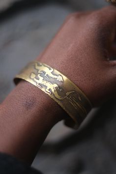 This vintage bracelet with a reptilian motif is unique with etchings one might have found on the walls of a prehistoric cave. Bohemian in mood, the gold-toned  brass piece  will look great layered with other unique jewelry you have collected over the years  condition: it is a little bent. not a real full-curve Symbolic Stamped Cuff Bangle Bracelet, Symbolic Stamped Cuff Bracelet, Adjustable Bracelet With Antique Finish, Unique Adjustable Bracelets With Antique Finish, Unique Adjustable Bracelet With Antique Finish, Adjustable Brass Etched Cuff Bracelet, Adjustable Etched Brass Cuff Bracelet, Symbolic Etched Cuff Bracelet Bangle, Symbolic Etched Bangle Cuff Bracelet