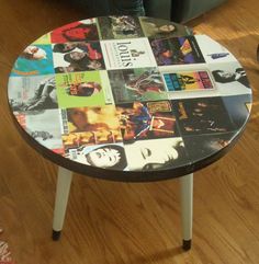 a round table with many pictures on it in a living room next to a couch