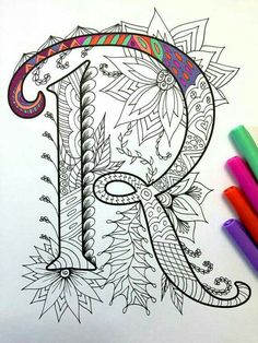 an adult coloring book with the letter r on it and colored pencils next to it