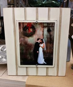 a wedding picture frame with a bride and groom kissing in front of a christmas wreath