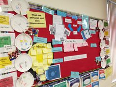 a bulletin board covered in papers and paper plates with words on it, all pinned together