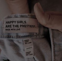 a person holding onto a label that says happy girls are the pretties made with love