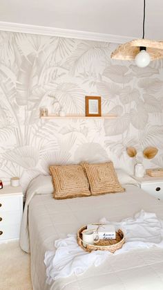 a bedroom with a bed, nightstands and wallpaper in white colors is shown