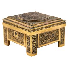 an ornately decorated wooden box on stand