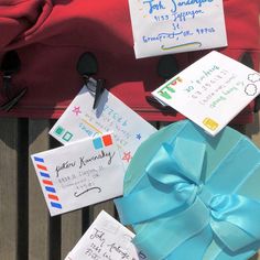 several pieces of paper with writing on them sitting next to a red bag and blue ribbon