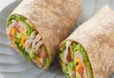 two wraps with meat, lettuce and cheese on them