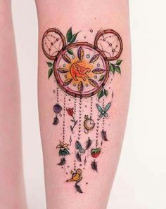 a woman's leg with tattoos on it and a clock in the shape of a mouse