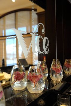 there are many wine glasses on the counter in front of the glass sign that says vice