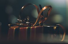 a gift wrapped in gold ribbon sitting on top of a table