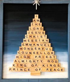 a christmas tree made out of scrabble tiles in front of a blue wall