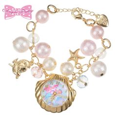 a gold bracelet with charms and an ocean theme clock on it's clasps