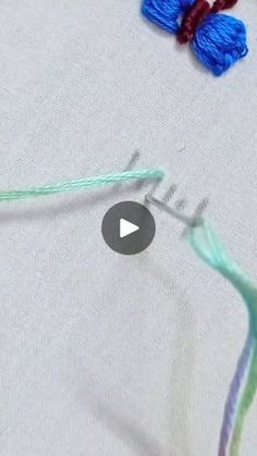 the video is showing how to crochet with yarn and needles on top of it