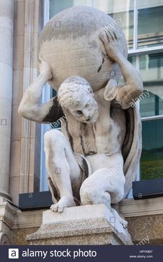 an old statue is sitting on the corner of a building