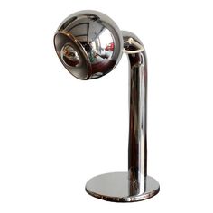 a chrome plated table lamp on a metal base with a round mirror in the middle