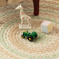 a toy tractor and giraffe sitting on a rug next to a wooden chair