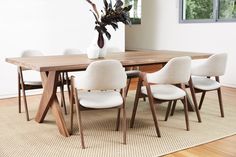 a wooden table with white chairs around it