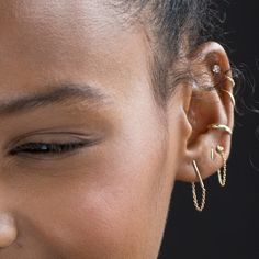 a close up of a person with ear piercings on their ears and nose rings