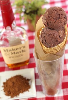 two ice cream cones sitting on top of a red and white checkered table cloth